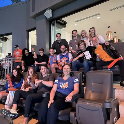 A large group seated in theatre seating, many in sports jerseys.