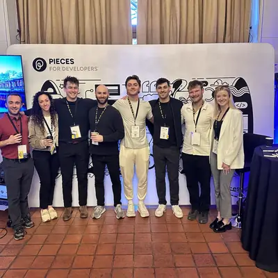 A team standing in front of a lit exhibition booth at a developer conference.